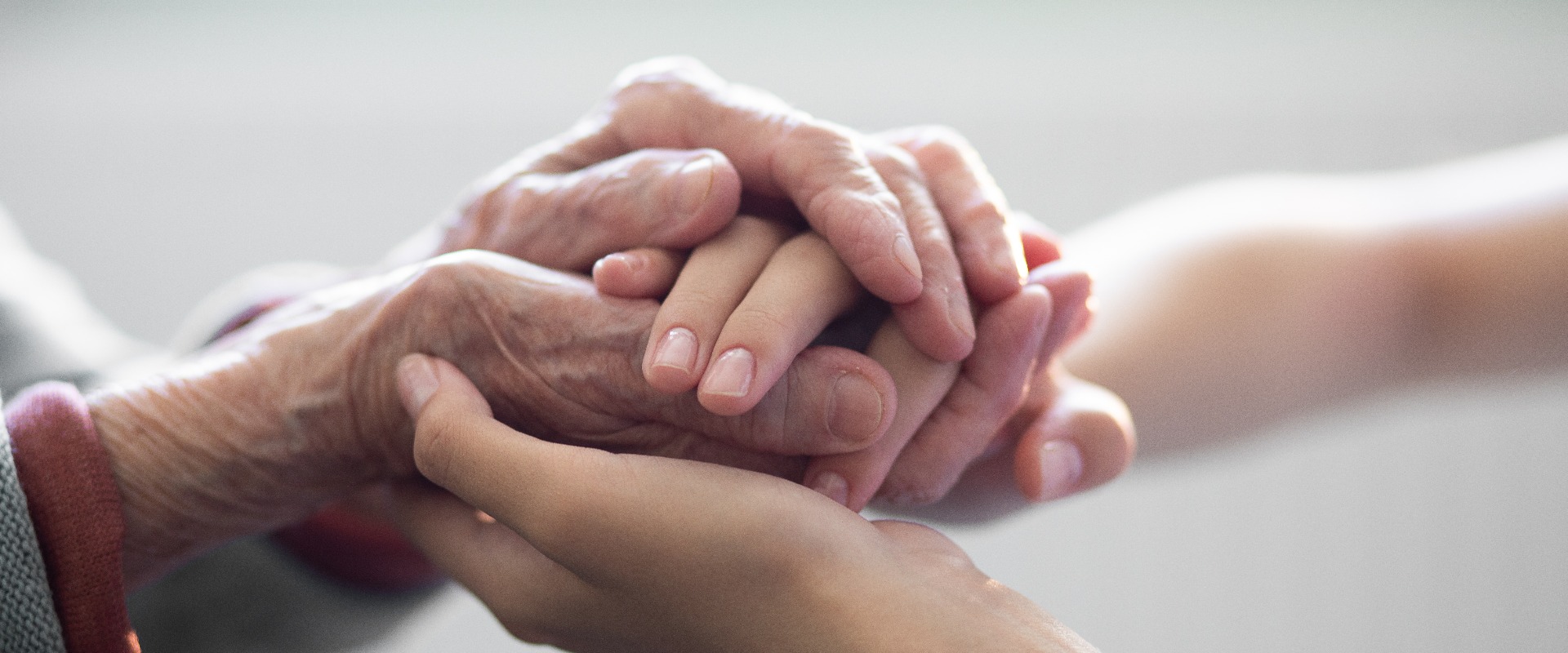 The hands of the child in the hands of the grandmother, the old brownish skin in the elderly woman, motherly love and care.